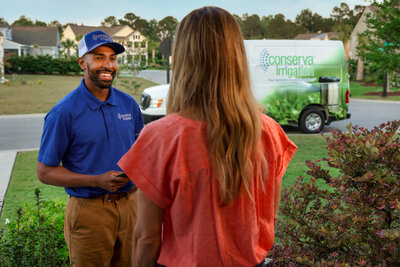 Conserva Irrigation tech greeting a homeowner before performing irrigation service